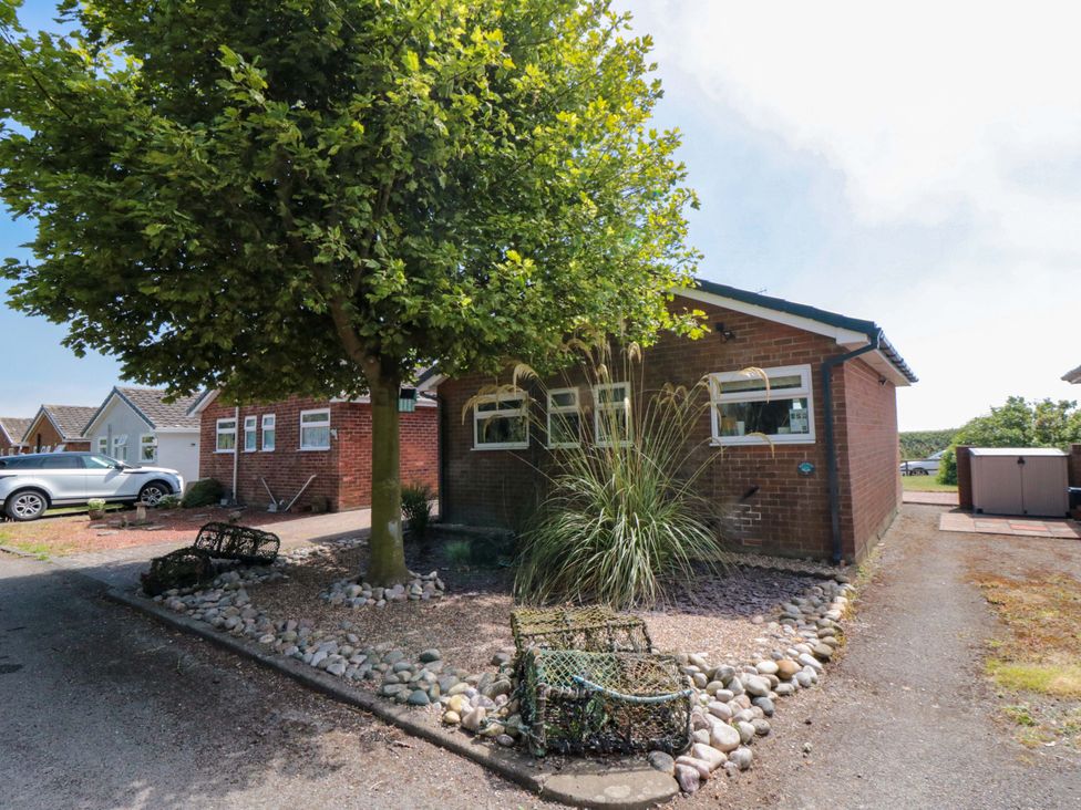 A house with a tree and stones in front at Beach House in 
