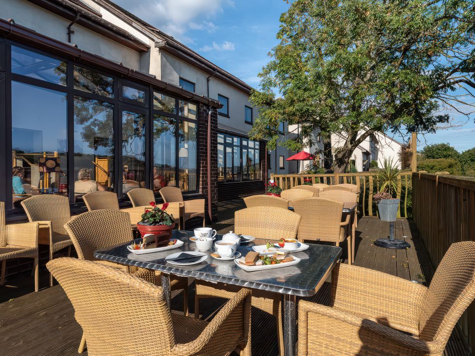 An outdoor patio with seating and food at Goldfinch in Kingsteignton