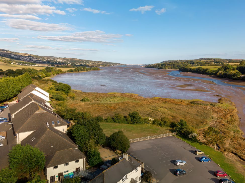 A view of a river and houses with a parking area at Moorhen in Kingsteignton