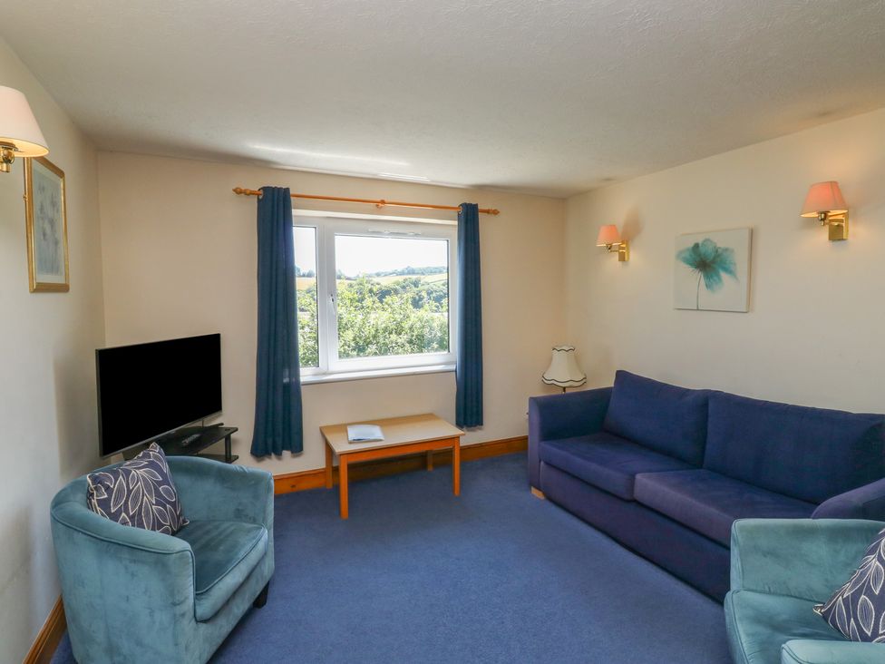 A living room with a sofa and television at Teal in Newton Abbot