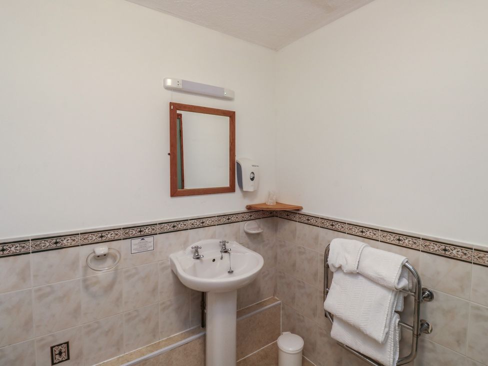 A bathroom with sink and mirror at Teal in Newton Abbot