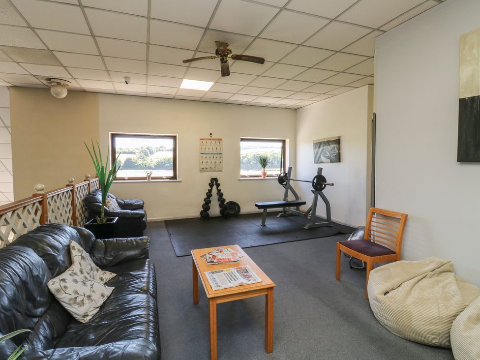 A gym with a weight bench and seating area at Teal in Newton Abbot