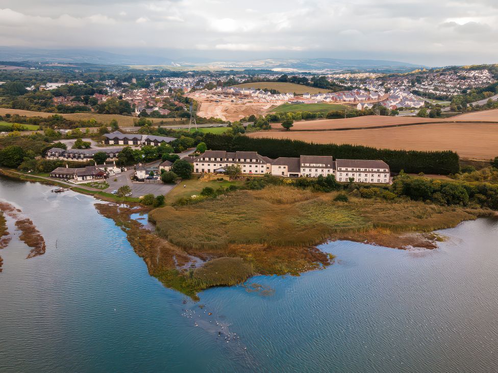 An aerial view of water and buildings near a field at Plover in Kingsteignton
