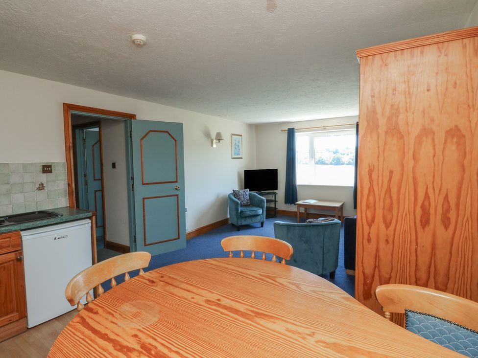 A living room with a kitchenette and furniture at Swift in Newton Abbot