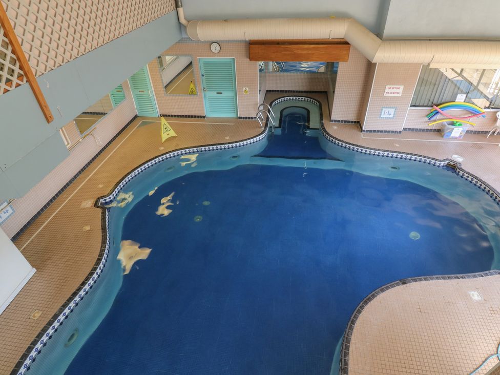 An indoor swimming pool with tile flooring at Swift in Newton Abbot