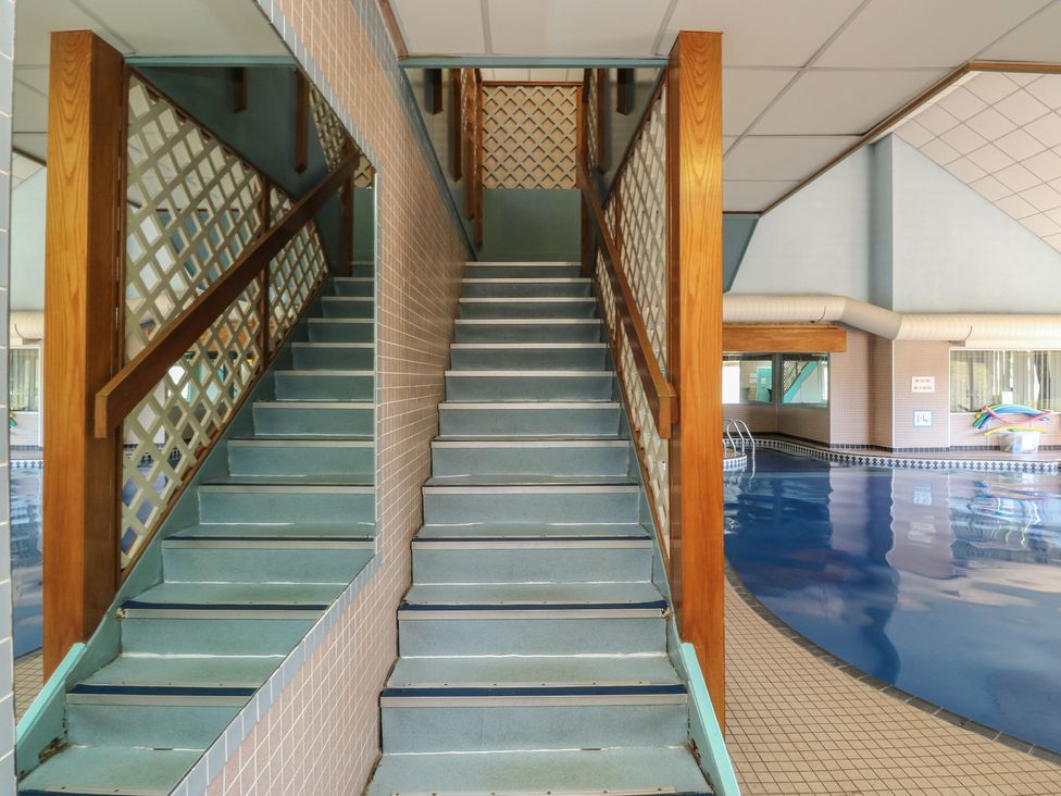 Staircase leading to upper level near a swimming pool at Swift in Newton Abbot