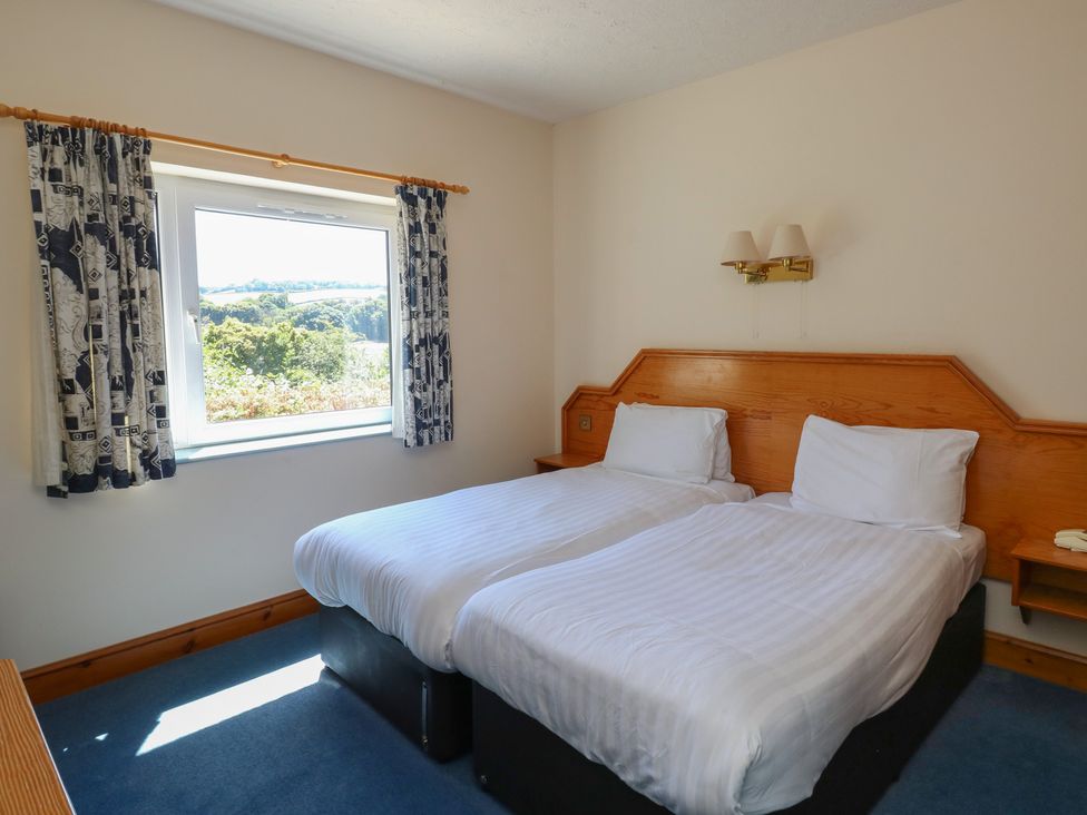 A bedroom with two beds and a window at Egret in Newton Abbot