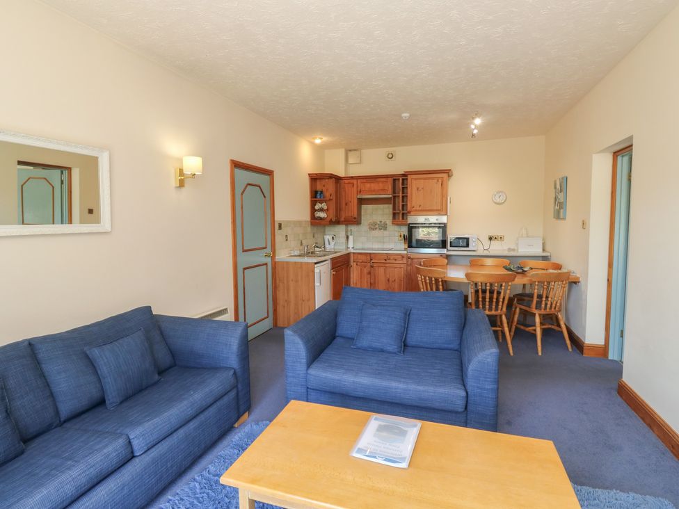 A living room with kitchen elements and a dining area at Avocet in Newton Abbot