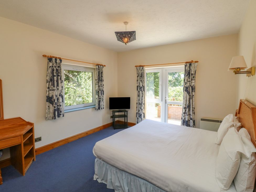 A bedroom with a bed and a television at Avocet Newton Abbot