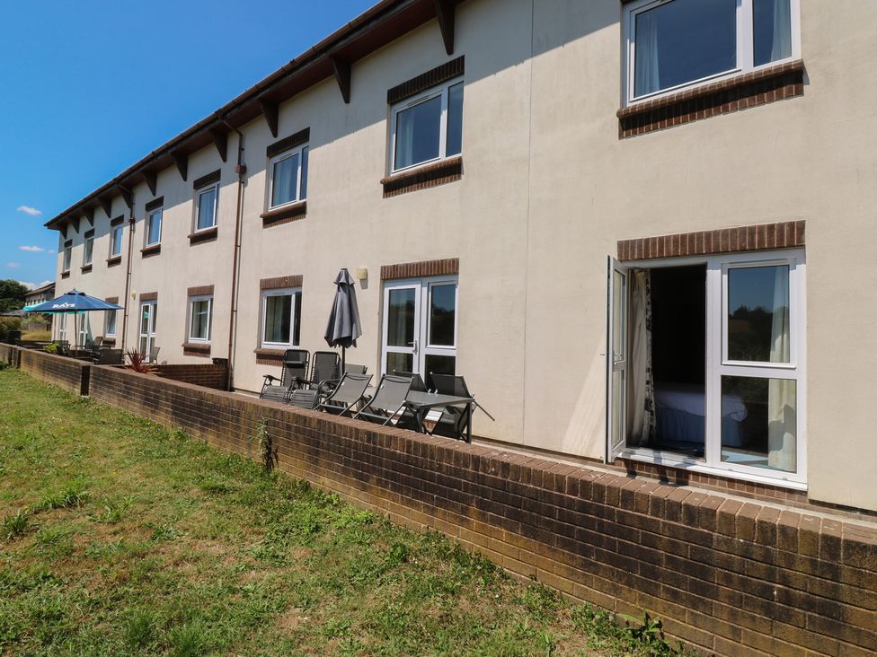 An outdoor area with seating and windows at Avocet in Newton Abbot