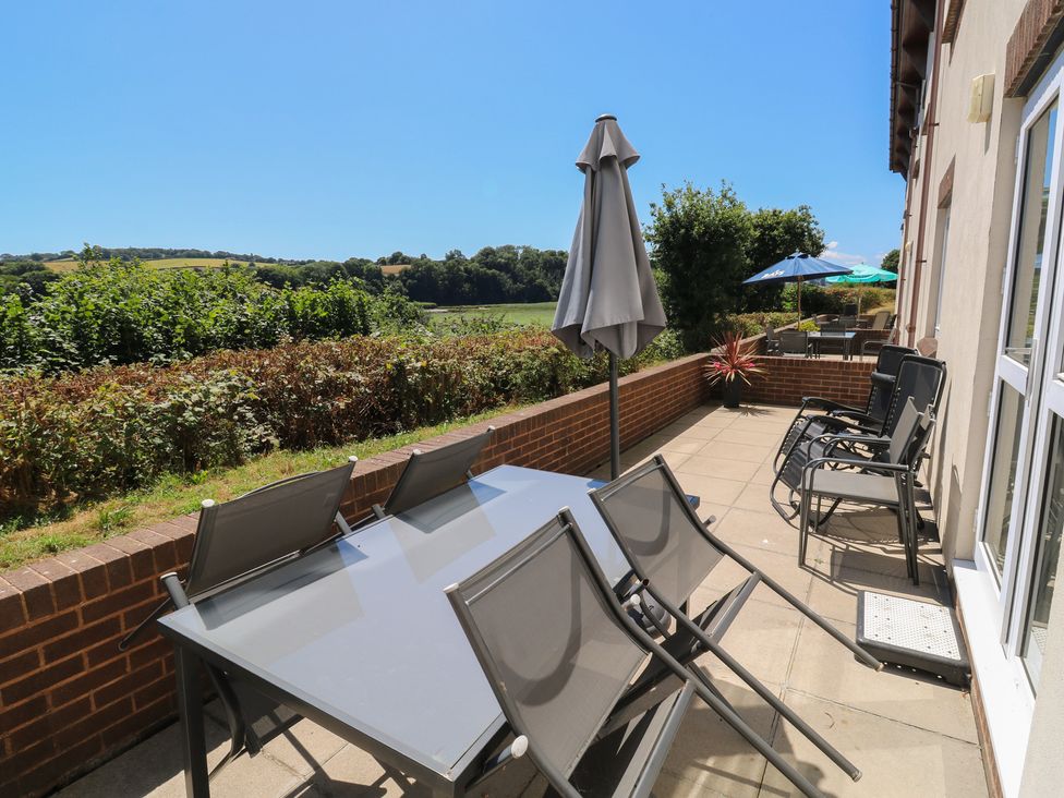 An outdoor terrace with a dining table and chairs at Avocet in Newton Abbot