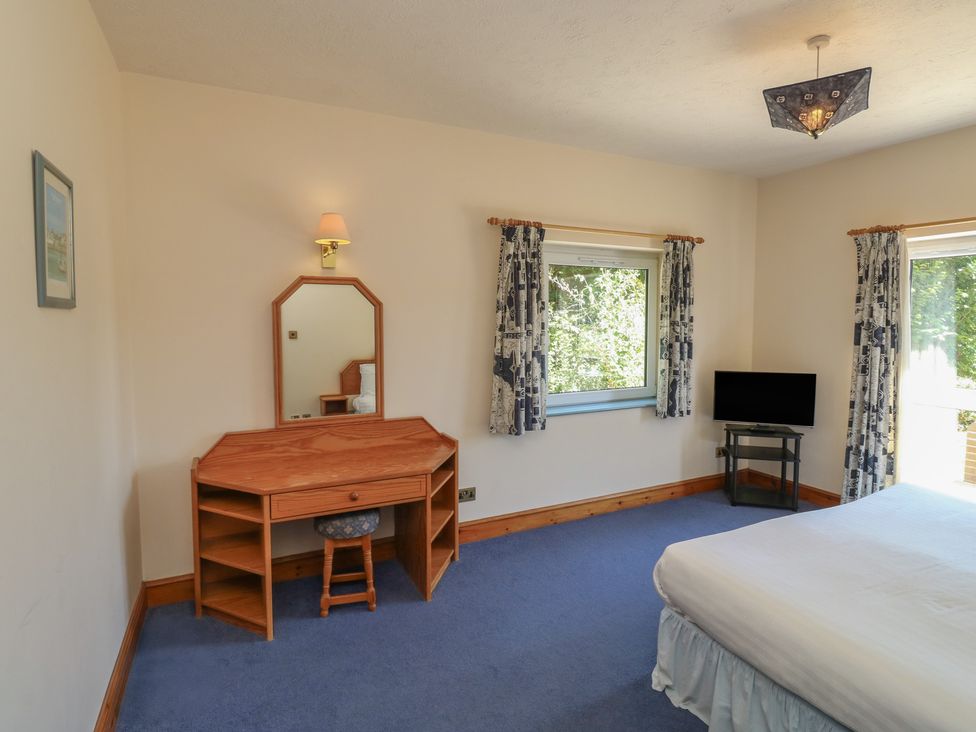 A bedroom with a desk and television at Avocet in Newton Abbot