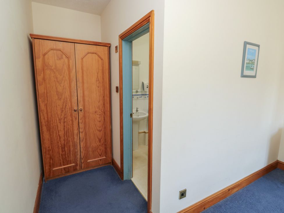 A hallway with a wardrobe and a door leading to a bathroom at Avocet in Newton Abbot