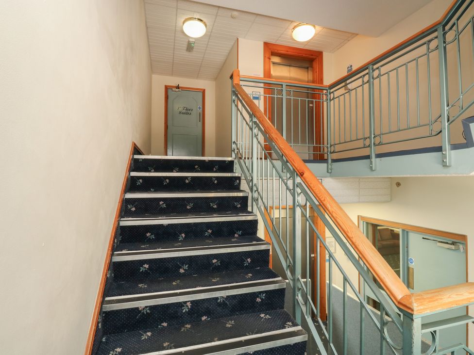A staircase leading to a door and elevator at Sycamore in Newton Abbot
