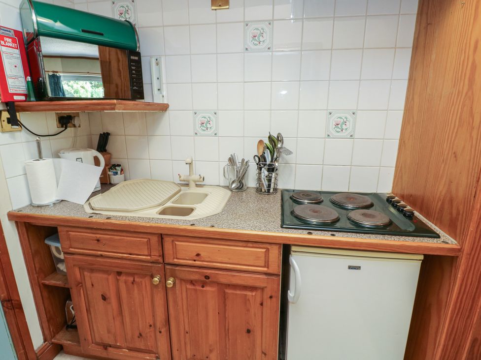 A kitchen with a sink and stove at Sycamore in Newton Abbot
