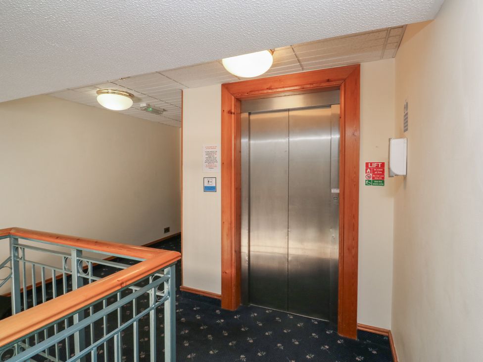 A hallway with an elevator and handrail at Sycamore, Newton Abbot