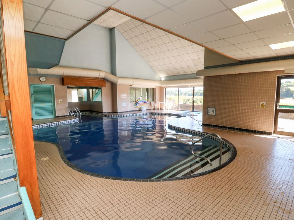 An indoor pool with tiles and windows at Sycamore in Newton Abbot