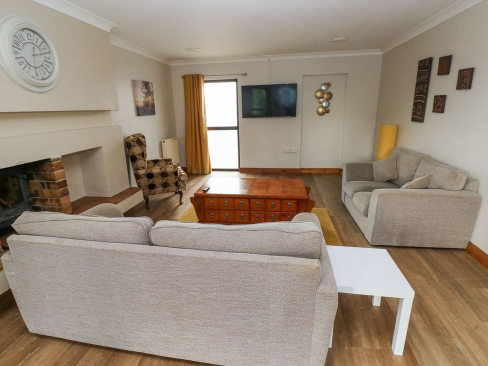 A living room with a sofa and a television at Tig Bhan in Narberth