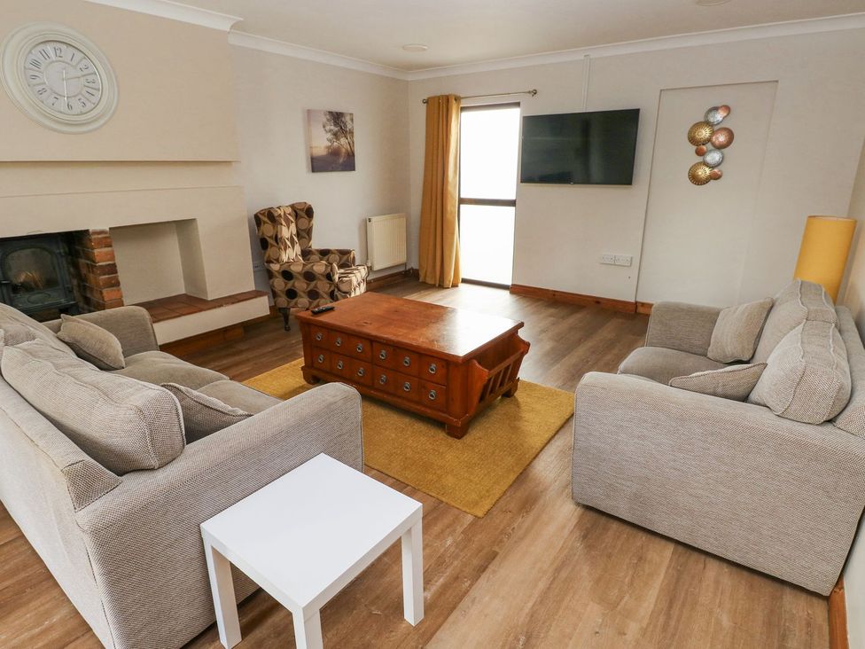 A living room with a sofa and armchair at Tig Bhan in Narberth