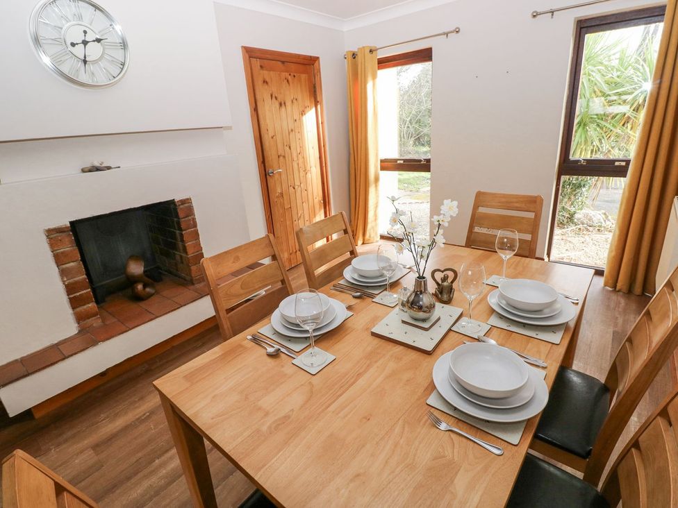 A dining room with a table set for dinner at Tig Bhan in Narberth