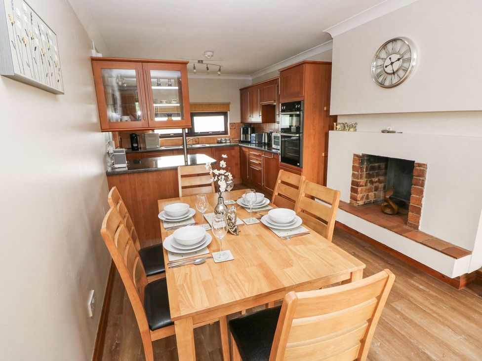 A kitchen with a dining table and chairs at Tig Bhan in Narberth