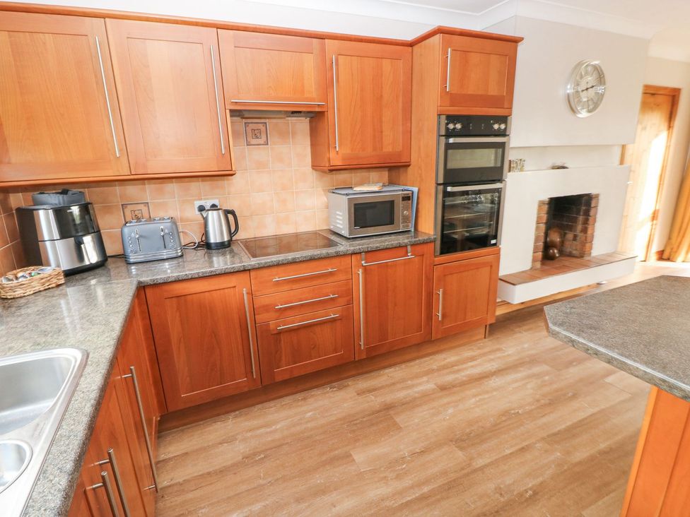 A kitchen with appliances and cabinets at Tig Bhan in Narberth