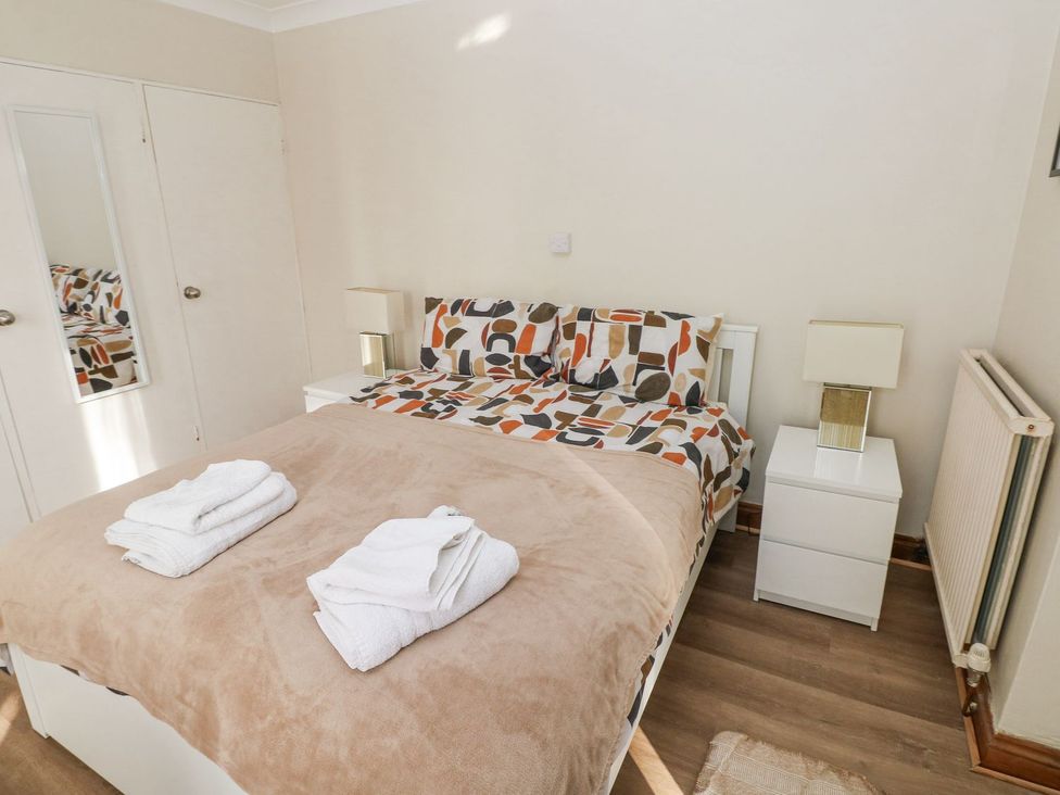 A bedroom with a bed and nightstands at Tig Bhan in Narberth