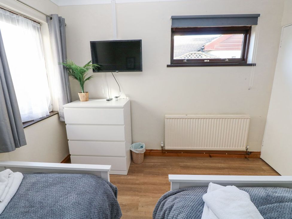A bedroom with a bed and television at Tig Bhan in Narberth