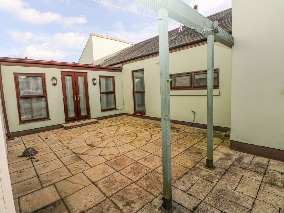 A patio area with doors and windows at Tig Bhan in Narberth