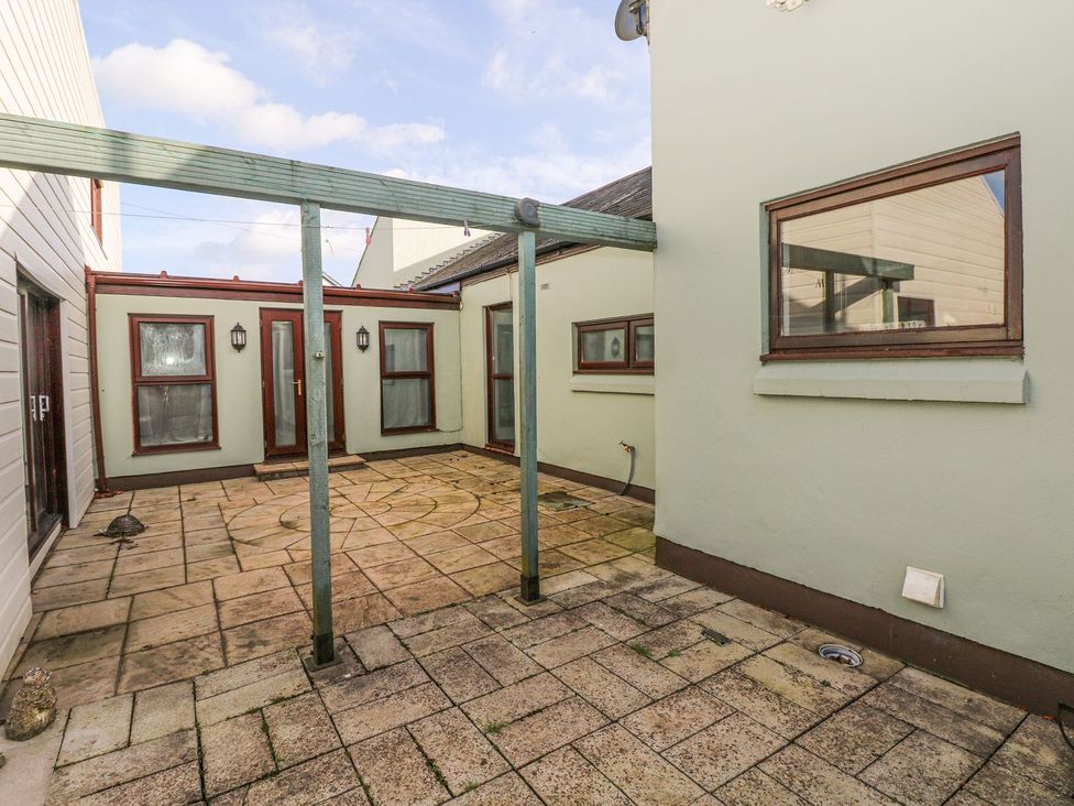 An outdoor area with a patio and surrounding walls at Tig Bhan in Narberth