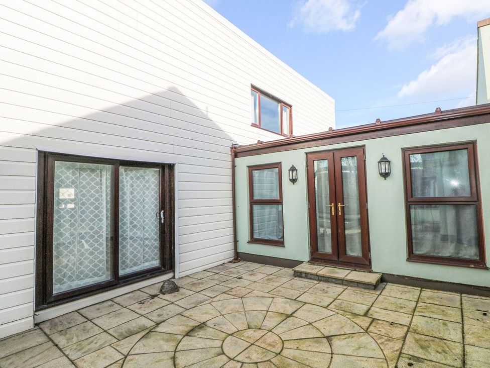 An outdoor area with a patio and doors at Cuddfan Narberth