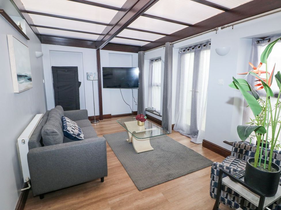 A living room with a sofa and television at Cuddfan in Narberth
