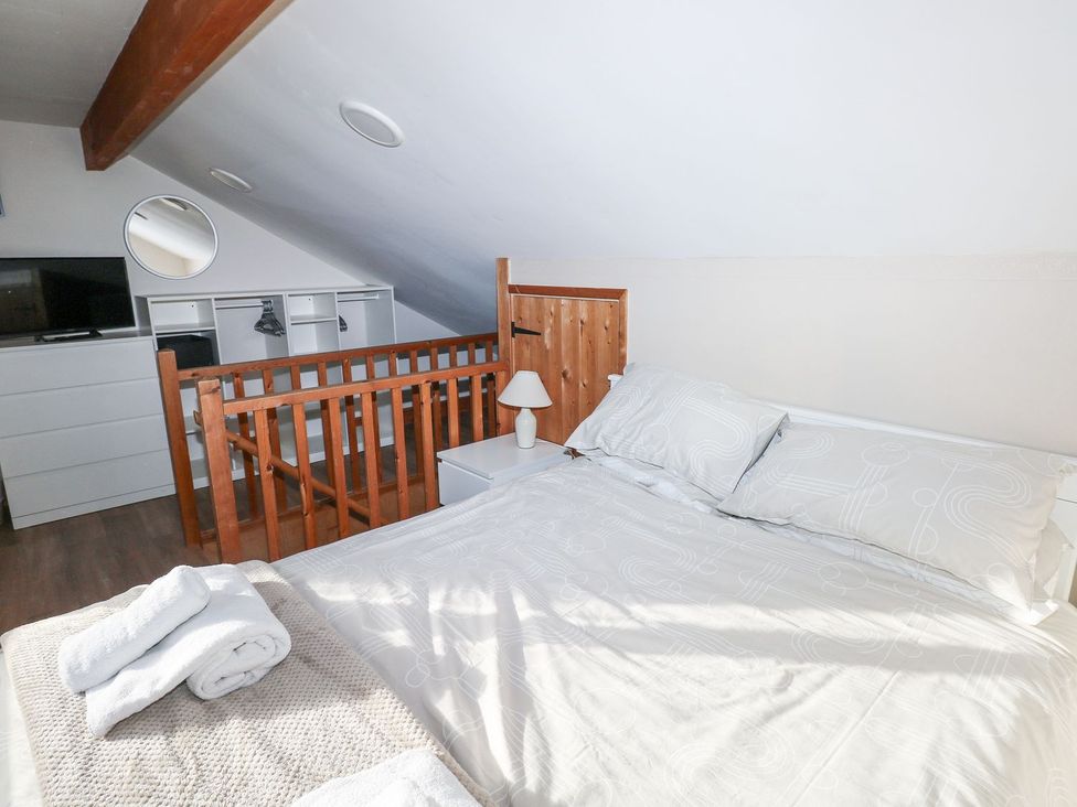 A bedroom with a bed and dresser at Cuddfan in Narberth