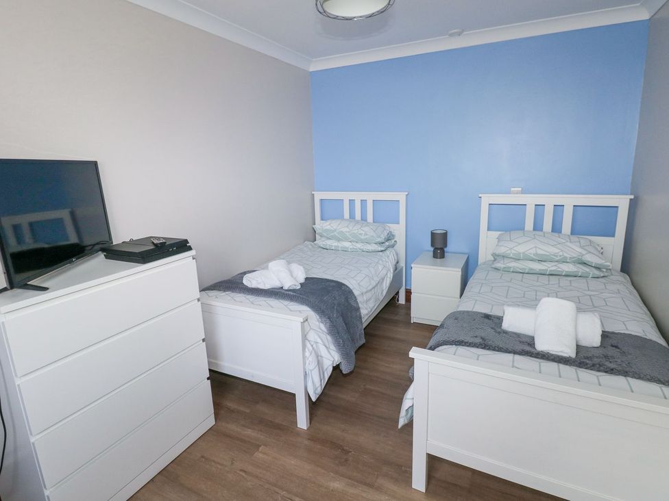 A bedroom with two single beds and a TV at Cuddfan in Narberth
