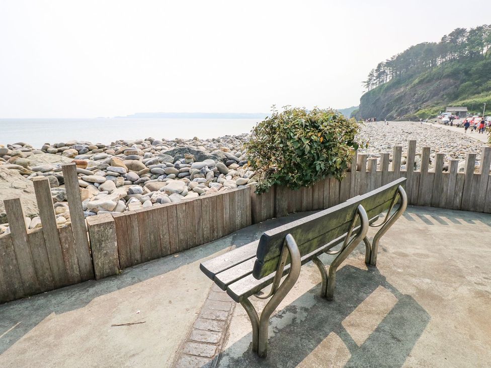A bench overlooking rocks and the sea at Cuddfan Narberth