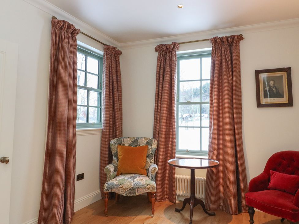 A sitting room with two windows and seating at Schiehallion House in Pitlochry