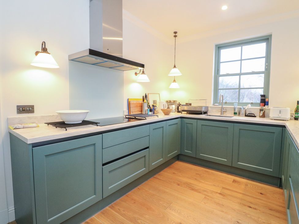 A kitchen with cabinets, a sink and a window at Schiehallion House in Pitlochry
