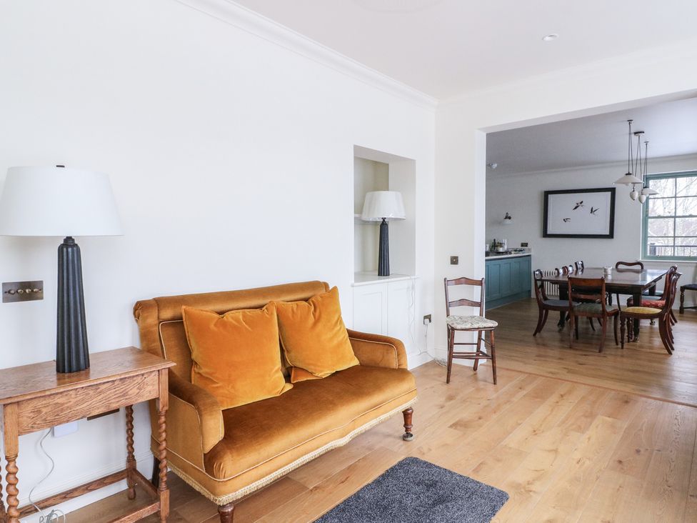 A living room with a sofa and lamp at Schiehallion House in Pitlochry