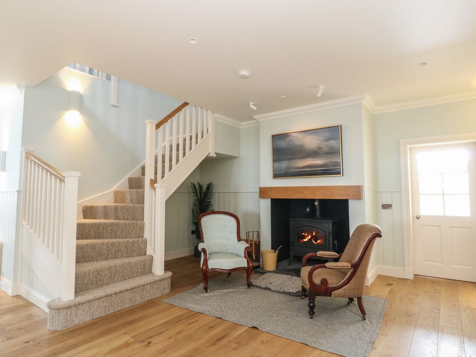 A living room with a fireplace and armchairs at Schiehallion House in Pitlochry