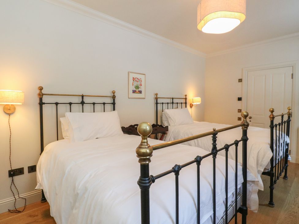 A bedroom with two single beds and a lamp at Schiehallion House in Pitlochry