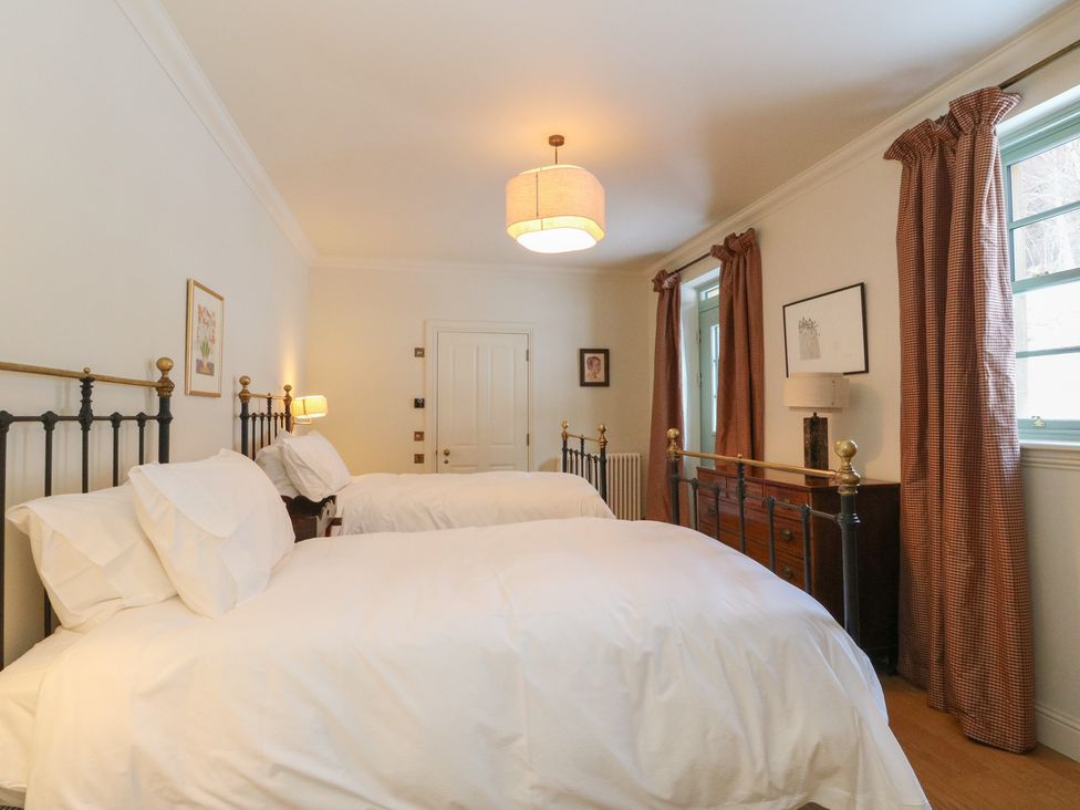A bedroom with two beds and a chest of drawers at Schiehallion House Pitlochry
