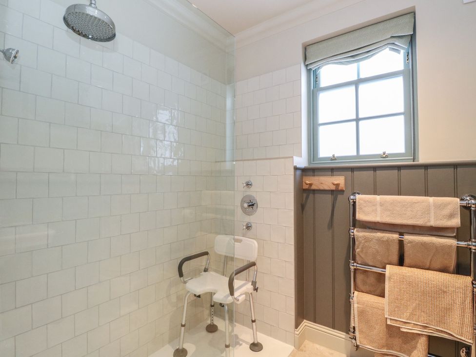 A bathroom with a shower and safety chair at Schiehallion House in Pitlochry