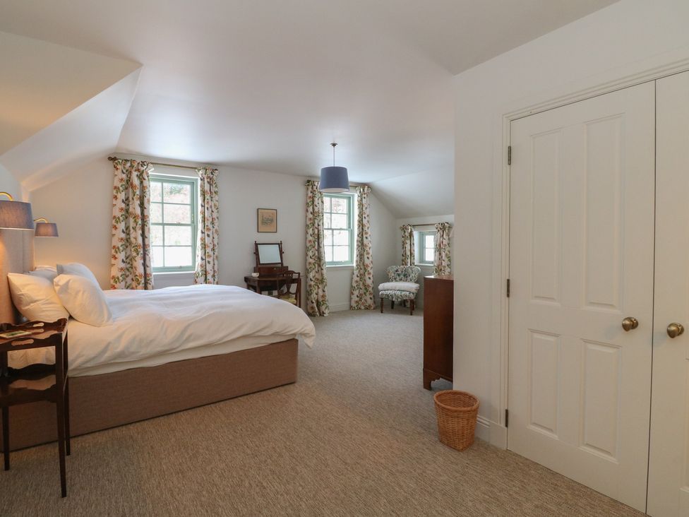 A bedroom with a bed and a sitting area at Schiehallion House Pitlochry