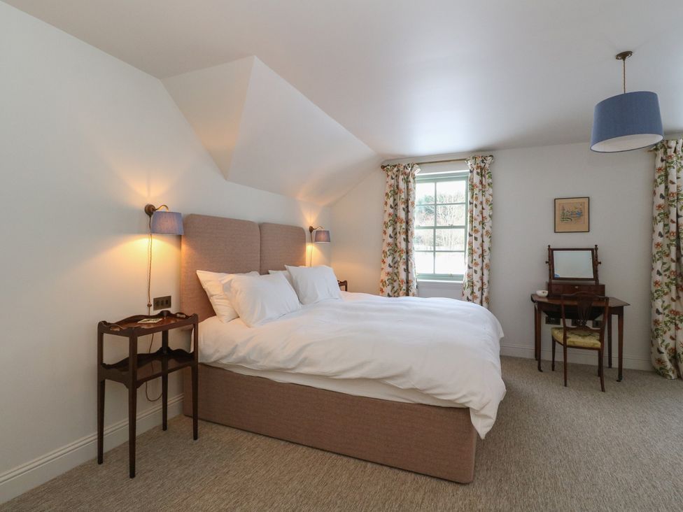 A bedroom with a bed and nightstand at Schiehallion House in Pitlochry