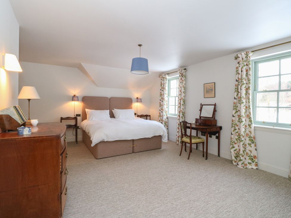 A bedroom with a bed and dressing table at Schiehallion House in Pitlochry