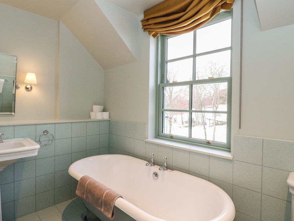 A bathroom with a bathtub and sink at Schiehallion House Pitlochry