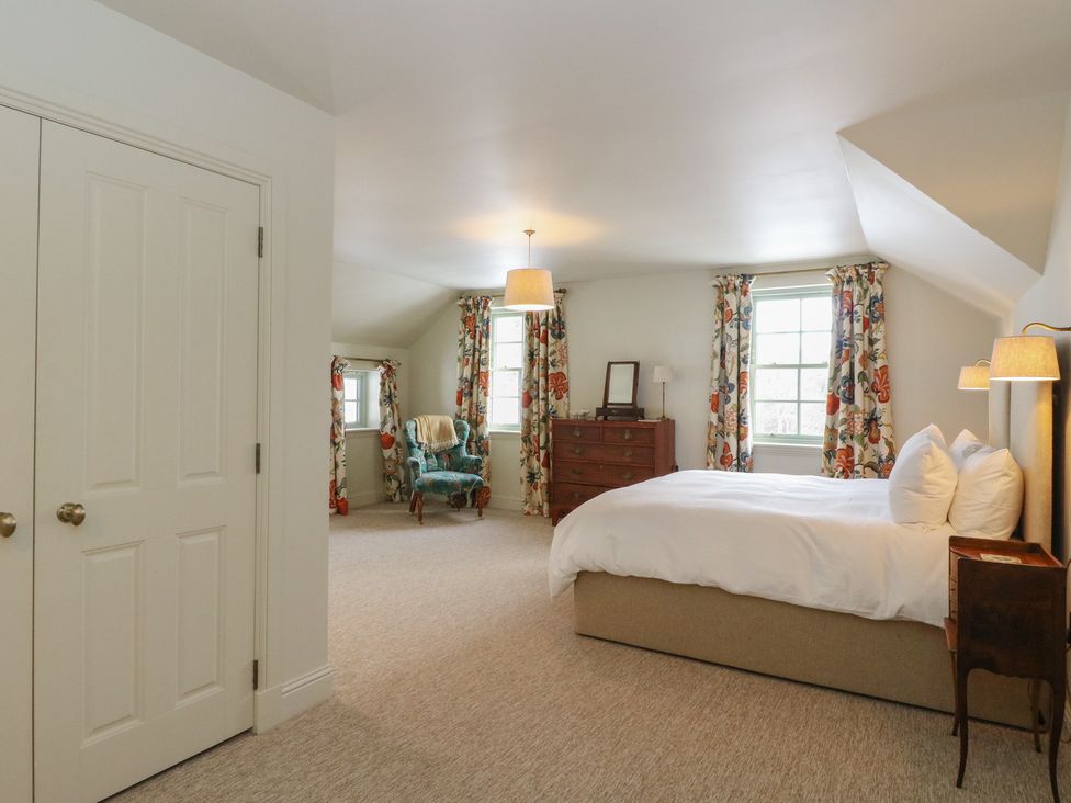 A bedroom with a bed and windows at Schiehallion House, Pitlochry