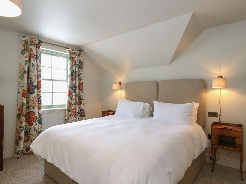 A bedroom with a bed and curtains at Schiehallion House Pitlochry