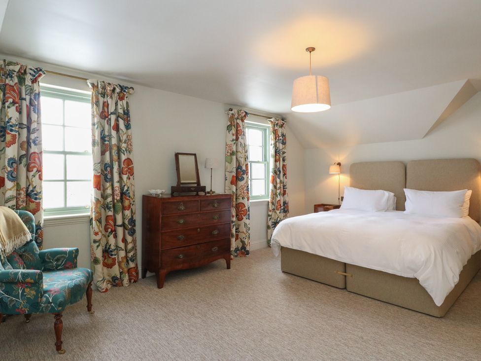 A bedroom with a bed and a dressing table at Schiehallion House in Pitlochry