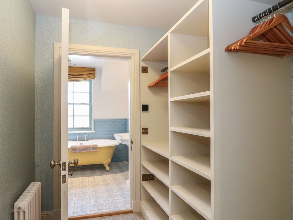 A bathroom with shelves and hangers at Schiehallion House in Pitlochry